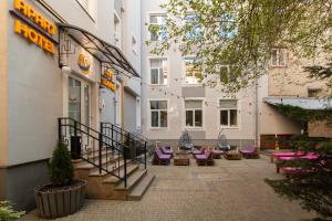 un patio de un hotel con sillas moradas y un edificio en Stories Hub, en Leópolis