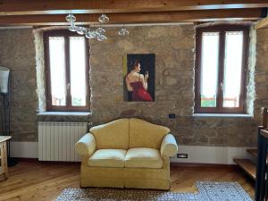 een woonkamer met een bank en een schilderij aan de muur bij B&B QUINTARELLI in San Pietro in Cariano