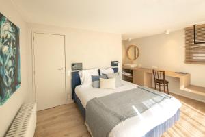 una camera con letto e scrivania con sedia di Guesthouse Brouwershuis a Poperinge