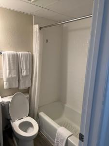 uma casa de banho com um WC e uma banheira com toalhas em Dunes Suites Oceanfront em Ocean City