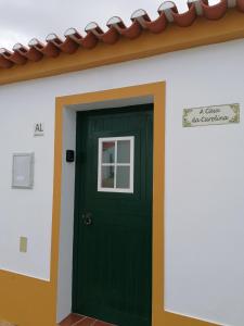 una puerta verde al lado de una casa en A Casa da Carolina, en Mértola