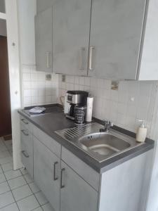 a kitchen counter with a sink and a coffee maker at Ferienwohnung ADARO in Schleswig