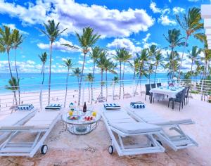 a picnic table on the beach with a view of the ocean at Dream Punta Cana Beachfront Apartment - 4-Bedroom Penthouse with Rooftop BBQ & Ocean Views in Punta Cana