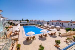 een uitzicht over een zwembad met parasols en tafels bij Naranjos Resort Menorca in S'Algar