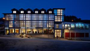 un grand bâtiment avec de nombreuses fenêtres la nuit dans l'établissement Abrigo da Montanha Hotel Rural, à Sabugueiro