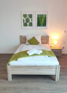 een slaapkamer met een bed met twee handdoeken erop bij greenpartment Boardinghousehotel Kelheim in Kelheim