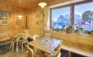 comedor con mesa, sillas y ventana en Mahlknechthuette Seiseralm, en Alpe di Siusi