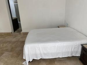 uma cama com um lençol branco num quarto em Hotel fresno Xochitepec em Chiconcuac