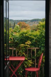 una ventana con una silla roja y una mesa en Les Cabottes, en Change