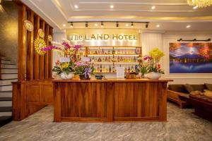 een lobby van een hotel met een bar met bloemen bij The Land Hotel & Apartment in Vung Tau