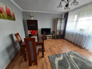 uma sala de estar com uma mesa e cadeiras e uma televisão em Słoneczny Apartament w Busku-Zdroju em Busko-Zdrój