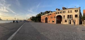 uma rua vazia junto à água com um edifício em Bricola Biennale Apartments em Veneza