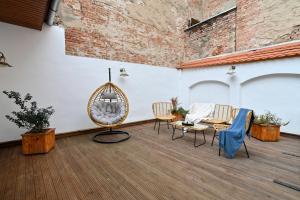 a patio with chairs and a table and a brick wall at Althof Apartments in Sibiu