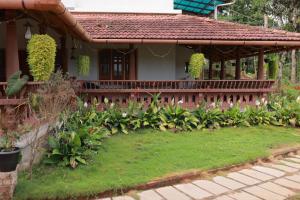 a house with a garden in front of it at Wayal Wayanad Heritage villa in Panamaram