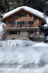 ein Holzhaus mit Schnee auf dem Dach in der Unterkunft La Ribambelle in Chamonix-Mont-Blanc