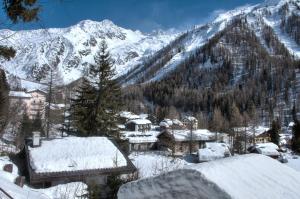 einen schneebedeckten Berg mit Häusern und Bäumen in der Unterkunft La Ribambelle in Chamonix-Mont-Blanc