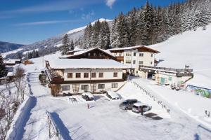 um alojamento de esqui com carros estacionados na neve em Jugend- und Familienhotel Venedigerhof em Neukirchen am Großvenediger