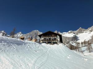 un lodge de esquí con nieve en las montañas en Berghotel Türlwand, en Ramsau am Dachstein