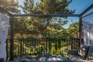 een afgeschermde veranda met een tafel en een bank bij Apartamenty In Patio Jurata in Jurata