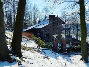 Ein altes Haus im Wald im Schnee in der Unterkunft Trumpet House in Löwen