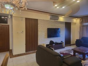 a person sitting in a chair in a living room with a tv at Meshaal heights in Mombasa