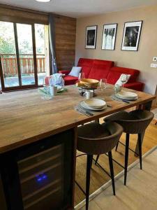 een woonkamer met een tafel met stoelen en een bank bij Gorgeous 2 bedroom, 2 full bath, ski in apartment! in Morzine