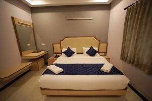 1 dormitorio con 1 cama grande con almohadas azules en Majestic Hotel, en Madurai