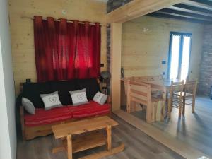 uma sala de estar com um sofá vermelho e uma mesa em La tanière du lac d Aiguebelette em Lepin-le-Lac