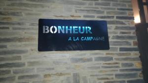 a sign for a la campana on a brick wall at Bonheur à la campagne in Bastogne