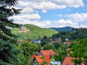 a small town in the mountains with houses and trees at Apartments Villa-Ratskopf Wernigerode in Wernigerode