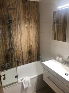 y baño con bañera y lavamanos. en Hotel Alpenland, en Niederau