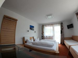 1 dormitorio con 2 camas, sofá y ventana en Hotel Alpenland, en Niederau