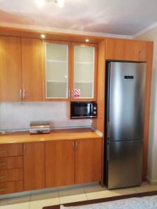 a kitchen with a stainless steel refrigerator and wooden cabinets at Dellmar Apartment in Perea