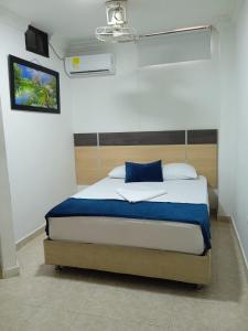 una camera con letto e cuscino blu di Hotel Caribe Real Inn a Santa Marta