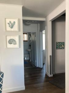 um corredor de uma casa com pinturas de quintal nas paredes em Guesthouse Cannon Beach em Cannon Beach