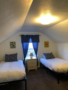 Duas camas num quarto com uma janela em Guesthouse Cannon Beach em Cannon Beach