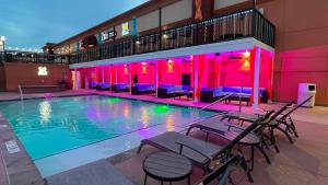 a pool with tables and chairs next to a building at Lux Hotel & Spa, Trademark Collection by Wyndham in Arlington