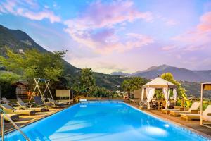 - une piscine dans un complexe avec des chaises et un kiosque dans l'établissement Ruster Resort, à Lagundo