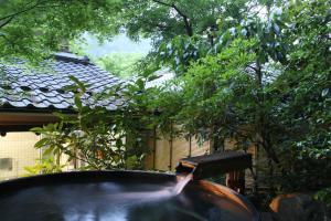 a stream of water in a large pot in a garden at Kyo no Minshuku Ohara no Sato in Kyoto