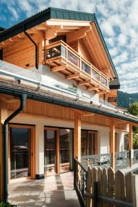 ein Haus mit Balkon darüber in der Unterkunft La Dila Dolomiti Mountain Lodge in Andalo