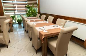 een eetkamer met een lange tafel en stoelen bij Hotel Leo in Peje