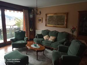 a living room with a green couch and chairs at Chez Vivi et Jean Pierre Maison 8 à 9 personnes au calme vue montagne WIFI in Gérardmer