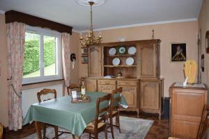 a dining room with a table and a cabinet at Chez Vivi et Jean Pierre Maison 8 à 9 personnes au calme vue montagne WIFI in Gérardmer