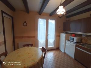 a kitchen with a table and a kitchen with a window at Chez Vivi et Jean Pierre Maison 8 à 9 personnes au calme vue montagne WIFI in Gérardmer