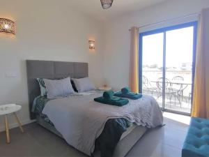 een slaapkamer met een groot bed en een groot raam bij Apartment 2 bedrooms , centre of Alvor, open view and private parking in Alvor