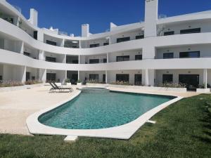 een groot wit appartementencomplex met een zwembad bij Apartment 2 bedrooms , centre of Alvor, open view and private parking in Alvor