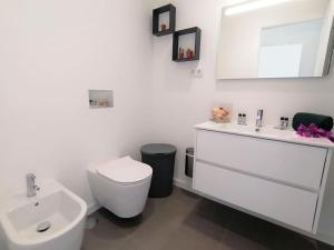 een witte badkamer met een toilet en een wastafel bij Apartment 2 bedrooms , centre of Alvor, open view and private parking in Alvor