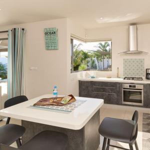 een keuken met een tafel en stoelen bij Villa Primera 3 bedroom bungalow with private pool Grand Bay in Grand Baie