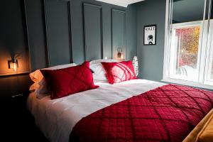 - une chambre dotée d'un lit rouge et blanc avec des oreillers rouges dans l'établissement The Old Post Office Warrington by Deuce Hotels, à Warrington