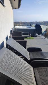 - un ensemble de chaises et de tables sur une terrasse dans l'établissement Gamma Apartmanok és Jakuzzi, à Miskolctapolca